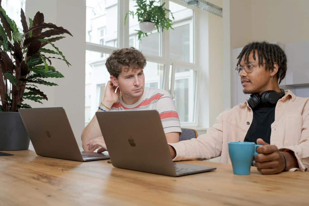 Two programmers in a modern office with their computers.